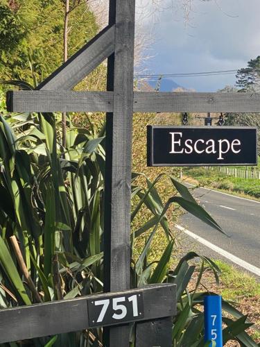 a sign that reads escape on the side of a road at Escape in New Plymouth
