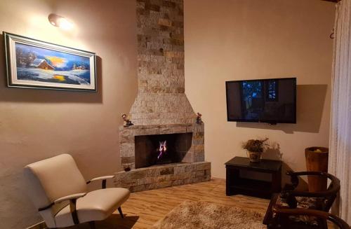 a living room with a stone fireplace with a tv at Chacara Diniz São Francisco Xavier in São José dos Campos