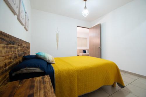 a bedroom with a bed with a yellow blanket at Isla Venados Renta Vacacional in Mazatlán