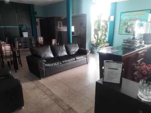 卡特馬科的住宿－HOTEL ACUARIO CATEMACO，客厅配有真皮沙发和桌子