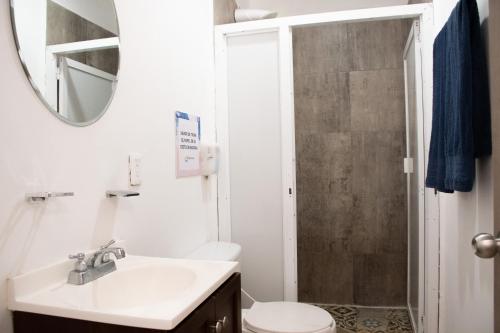 a bathroom with a toilet and a sink and a mirror at Isla Venados Renta Vacacional in Mazatlán