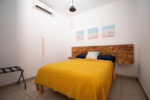 a bedroom with a bed with a yellow blanket at Isla Venados Renta Vacacional in Mazatlán