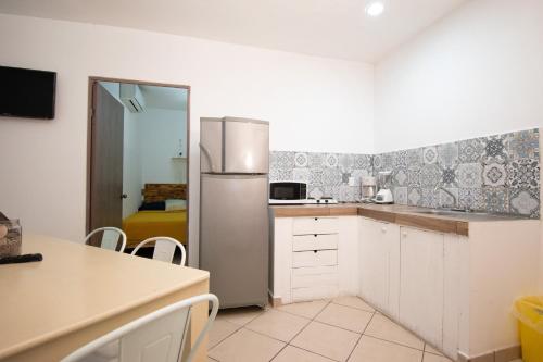 a kitchen with a refrigerator and a table and chairs at Isla Venados Renta Vacacional in Mazatlán