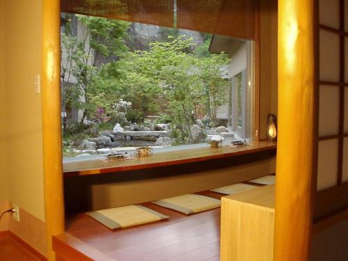 a bathroom with a window with a view of a garden at Keiryuso Siorie in Matsumoto