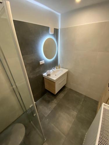 a bathroom with a sink and a mirror at Apartmany ROSTER in Liptovský Mikuláš