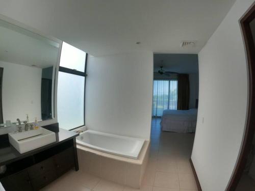 La salle de bains blanche est pourvue d'un lavabo et d'un miroir. dans l'établissement Jaco Carara Nativa Garden Suite ELEGANTE&EXCLISIVO, à Puntarenas