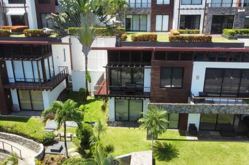 an aerial view of an apartment complex with palm trees at Jaco Carara Nativa Garden Suite ELEGANTE&EXCLISIVO in Puntarenas
