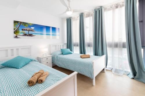 two beds in a bedroom with blue and white at LOLA'S HOME in Cotillo