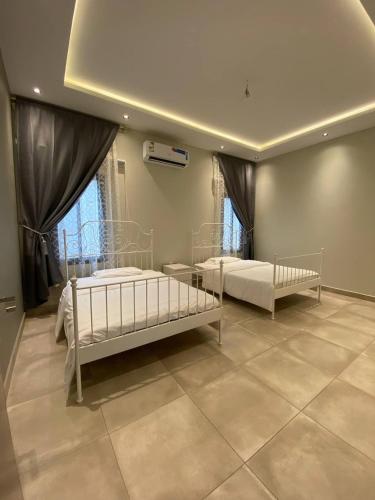 een slaapkamer met 2 bedden en een plafond bij شاليهات ضوء in Taif