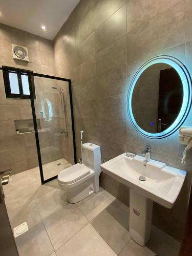 a bathroom with a toilet and a sink and a mirror at شاليهات ضوء in Taif