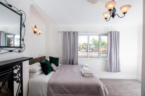 a bedroom with a bed with a mirror and a window at Ultimate Comfort 4-Bedroom Property for 7 People in Bromley