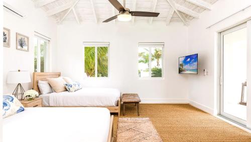 a bedroom with two beds and a ceiling fan at New Luxury 8 Bedroom Sunset Bay Villa in Long Bay Hills