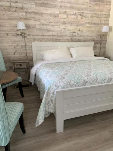 a bedroom with a white bed and a wooden wall at Inn on Canyon in Radium Hot Springs
