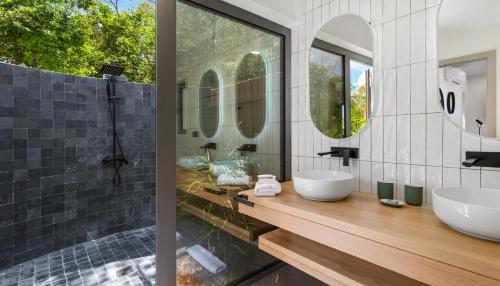 a bathroom with two sinks and two mirrors at Enjoy Villa - Completely NEW! in Baie Longue