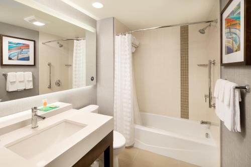 a bathroom with a sink and a tub and a toilet at Hyatt Place Santa Cruz in Santa Cruz