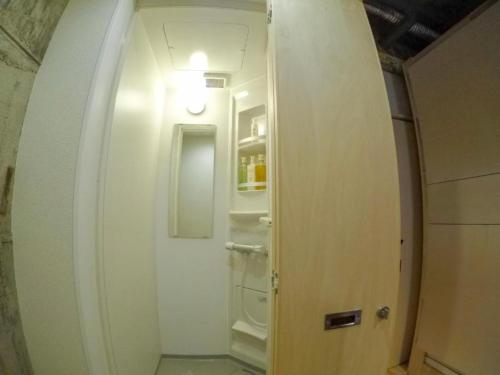 a hallway leading to a bathroom with a white door at Konyamachi Guest House Kuku - Vacation STAY 72725v in Takamatsu