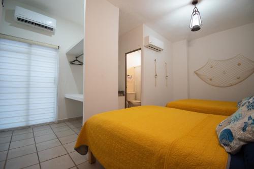a bedroom with a yellow bed and a mirror at Isla Venados Renta Vacacional in Mazatlán