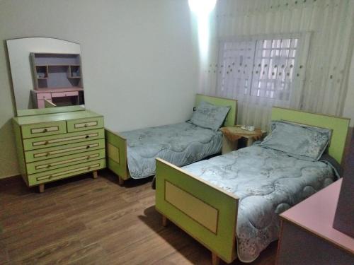 um quarto com 2 camas, uma cómoda e um espelho em City Center Furnished Apartment em Madaba