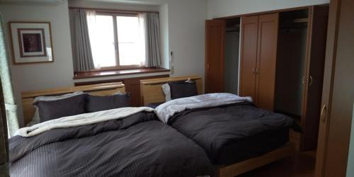 dos camas sentadas una al lado de la otra en un dormitorio en Minami Aso Guest House Hana hana - Vacation STAY 13316 en Takamori