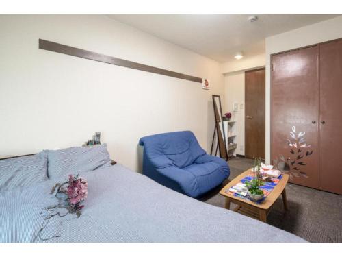 um quarto com uma cama azul e uma cadeira azul em cozy house - Vacation STAY 13159 em Quioto