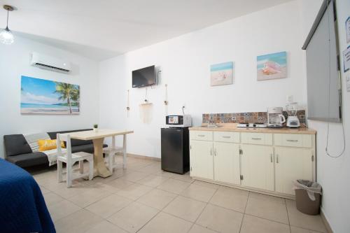 a kitchen and living room with a table and a couch at Isla Venados Renta Vacacional in Mazatlán