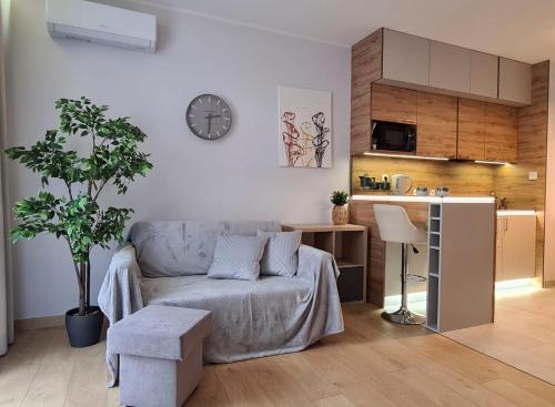 - un salon avec un canapé et un réveil sur le mur dans l'établissement Malta Delux Apartment, free parking, self check-in 24h, à Poznań