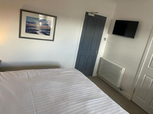 a bedroom with a bed and a blue door at Loch Lomond Hotel in Balloch