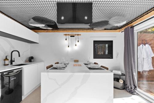a kitchen with white counters and a white counter top at Les Petits Chalets in Val-des-Lacs
