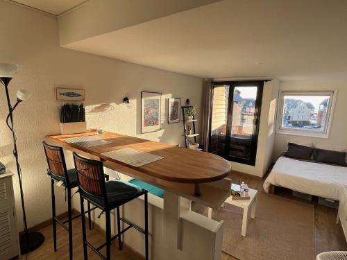 a room with a table and chairs and a bed at Appartement La Marina Deauville in Deauville