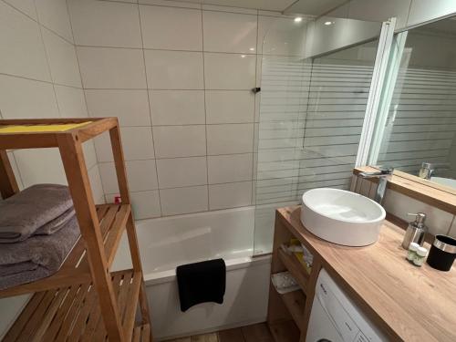 a bathroom with a sink and a bath tub at Appartement La Marina Deauville in Deauville