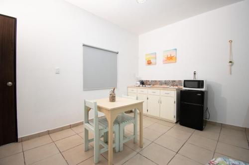 a kitchen with a small table and a refrigerator at Isla Venados Renta Vacacional in Mazatlán