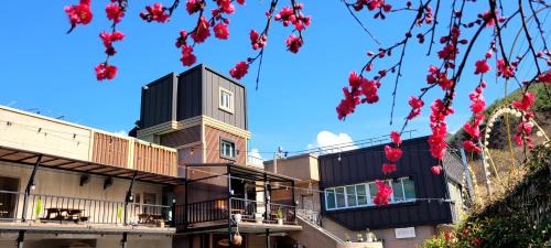 Un edificio con flores rojas en el frente. en RG Pension, en Hadong