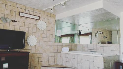 a bathroom with a sink, toilet, and bathtub at The Classic Desert Aire Hotel in Alamogordo