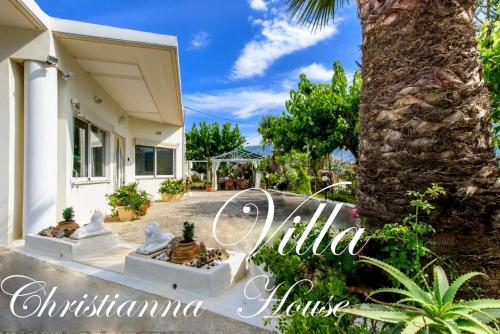 a villa with a palm tree and a house at Christianna House -Villa in Georgioupolis