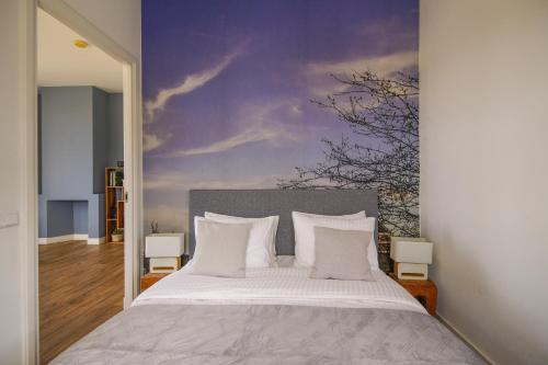 a bedroom with a large bed with a painting on the wall at 2L De Volharding in Leiden
