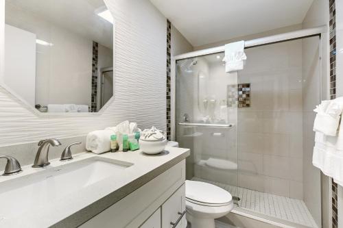 a white bathroom with a toilet and a sink at Newly decorated condo in beautiful beachfront resort in South Padre Island