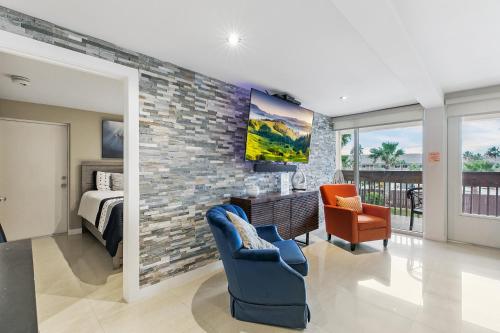 1 dormitorio y sala de estar con pared de ladrillo. en Newly decorated condo in beautiful beachfront resort, en South Padre Island