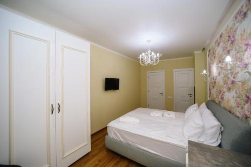 a small bedroom with a bed and a chandelier at Rose Hotel Vake in Tbilisi City