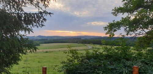 a green field with a dirt road in the distance at Les Rochettes, joli appartement, tout neuf, calme et paisible in Saint-Gervais-dʼAuvergne