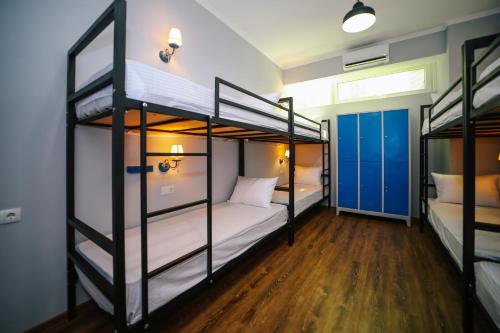 Rose Hotel & Hostel Vake في تبليسي: سريرين بطابقين في غرفة مع أرضيات خشبية