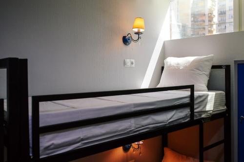 Ce lit superposé se trouve dans un dortoir doté d'une lumière sur le mur. dans l'établissement Rose Hotel & Hostel Vake, à Tbilissi