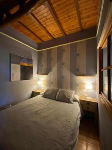 1 dormitorio con 1 cama, 2 mesas y una ventana en Agradable chalet rústico en Cambre