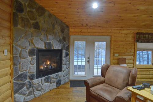a living room with a stone wall with a fireplace at The Lodges at Sunset Village in McHenry