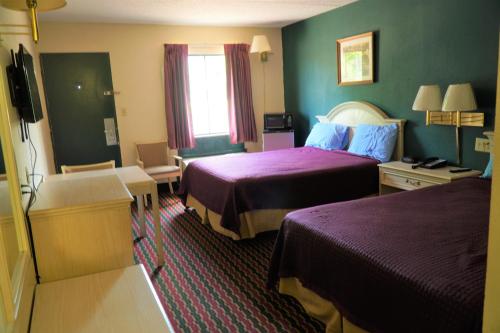 Habitación de hotel con 2 camas y TV en Quality Quarters Inn, en Richmond