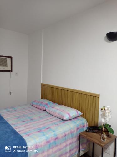 a bedroom with a bed and a table at Flat Palladim in São Vicente