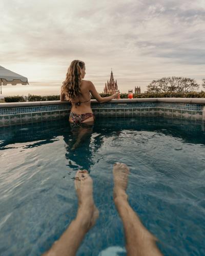 a woman in a swimming pool with her feet in the water at Casa de Sierra Nevada, A Belmond Hotel, San Miguel de Allende in San Miguel de Allende