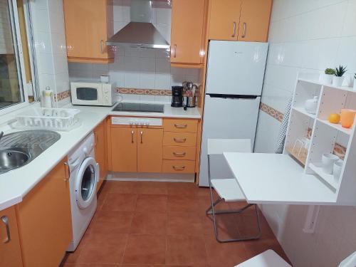 a kitchen with a white refrigerator and a sink at Ático Vacacional Manzanilla in Sanlúcar de Barrameda
