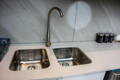a stainless steel kitchen sink with a faucet at The Menlyn Main Residents Trilogy in Pretoria