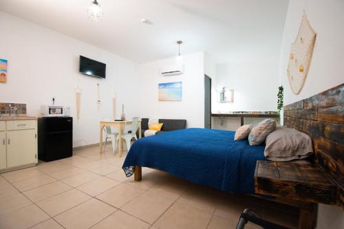 a bedroom with a blue bed and a kitchen at Isla Venados Renta Vacacional in Mazatlán