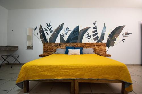 a bedroom with a bed with a yellow bedspread at Isla Venados Renta Vacacional in Mazatlán